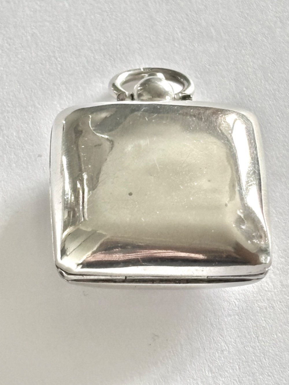 An open Edwardian square sterling silver sovereign case featuring a spring-loaded coin holder and stamped hallmarks on the interior lid. View IV