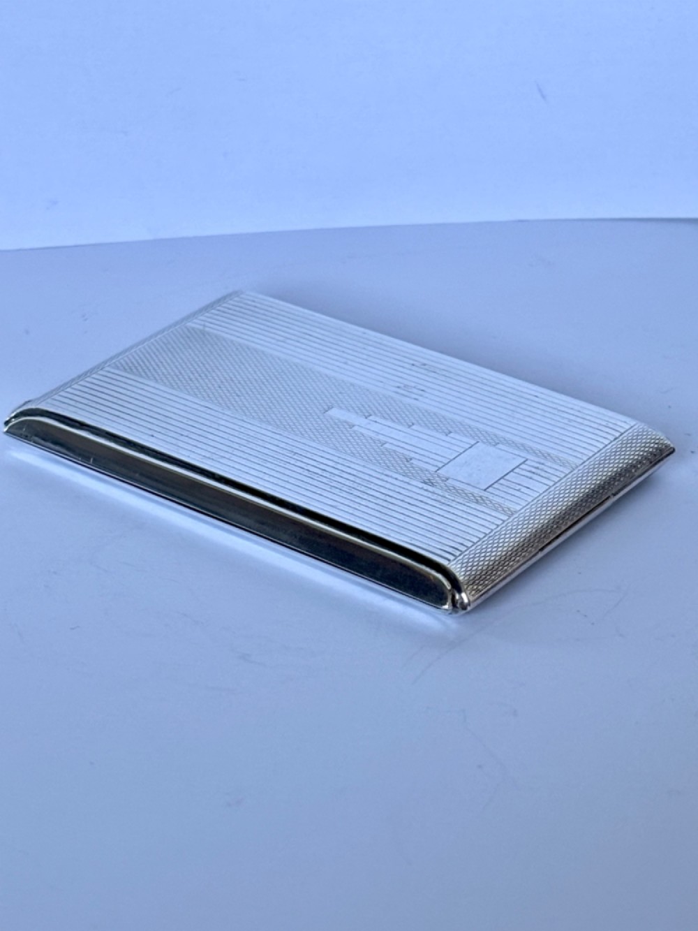 A square sterling silver Art Deco powder compact featuring linear engine-turned patterns and a central geometric stepped motif. View III