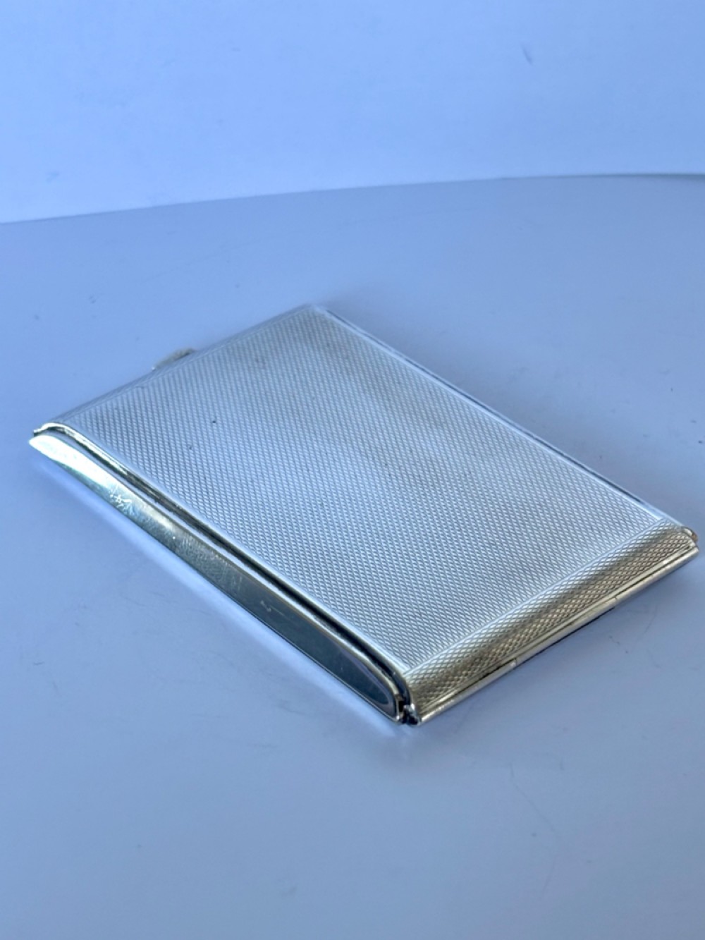 A square sterling silver Art Deco powder compact featuring linear engine-turned patterns and a central geometric stepped motif. View V
