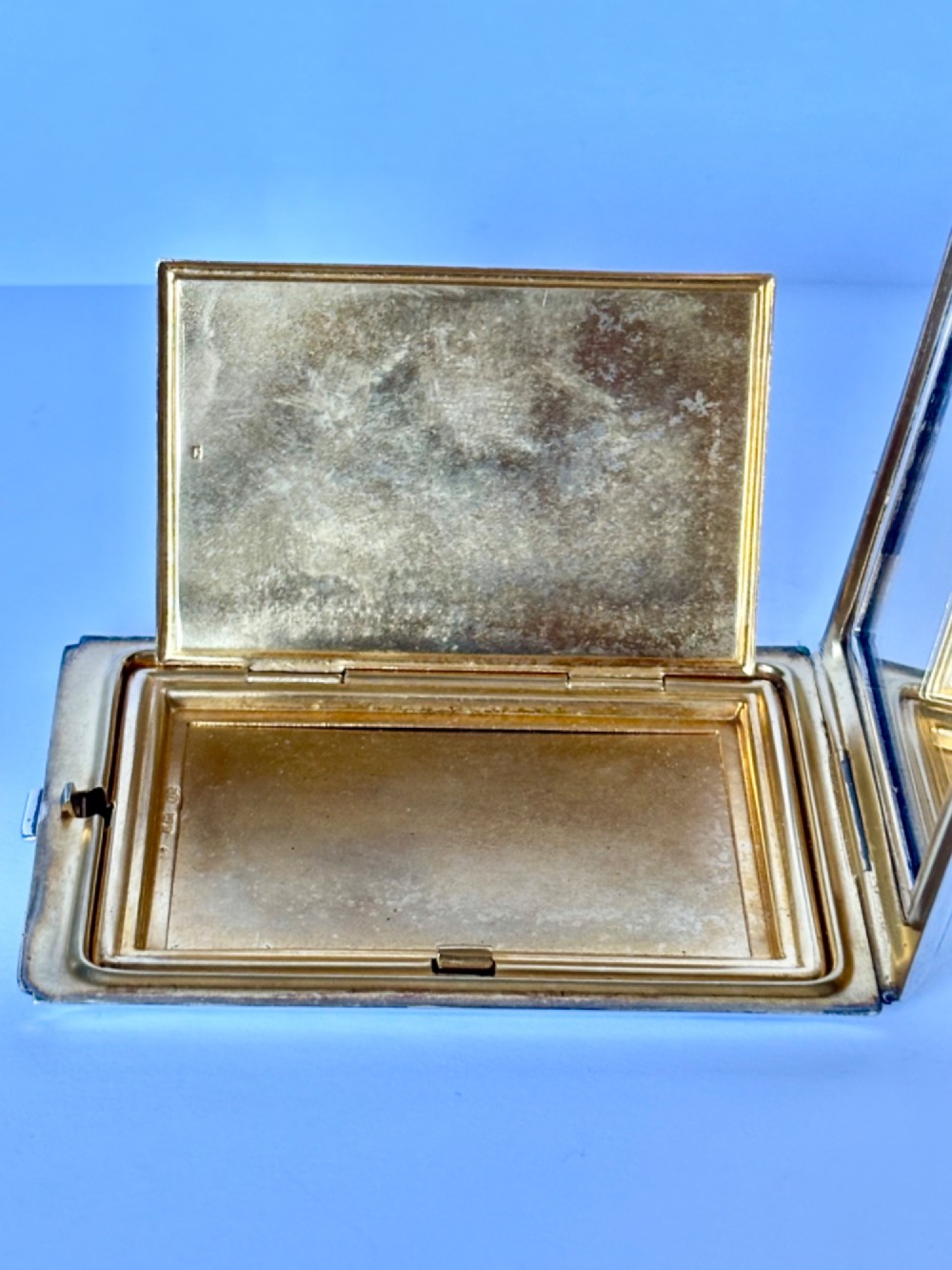 A square sterling silver Art Deco powder compact featuring linear engine-turned patterns and a central geometric stepped motif. View X