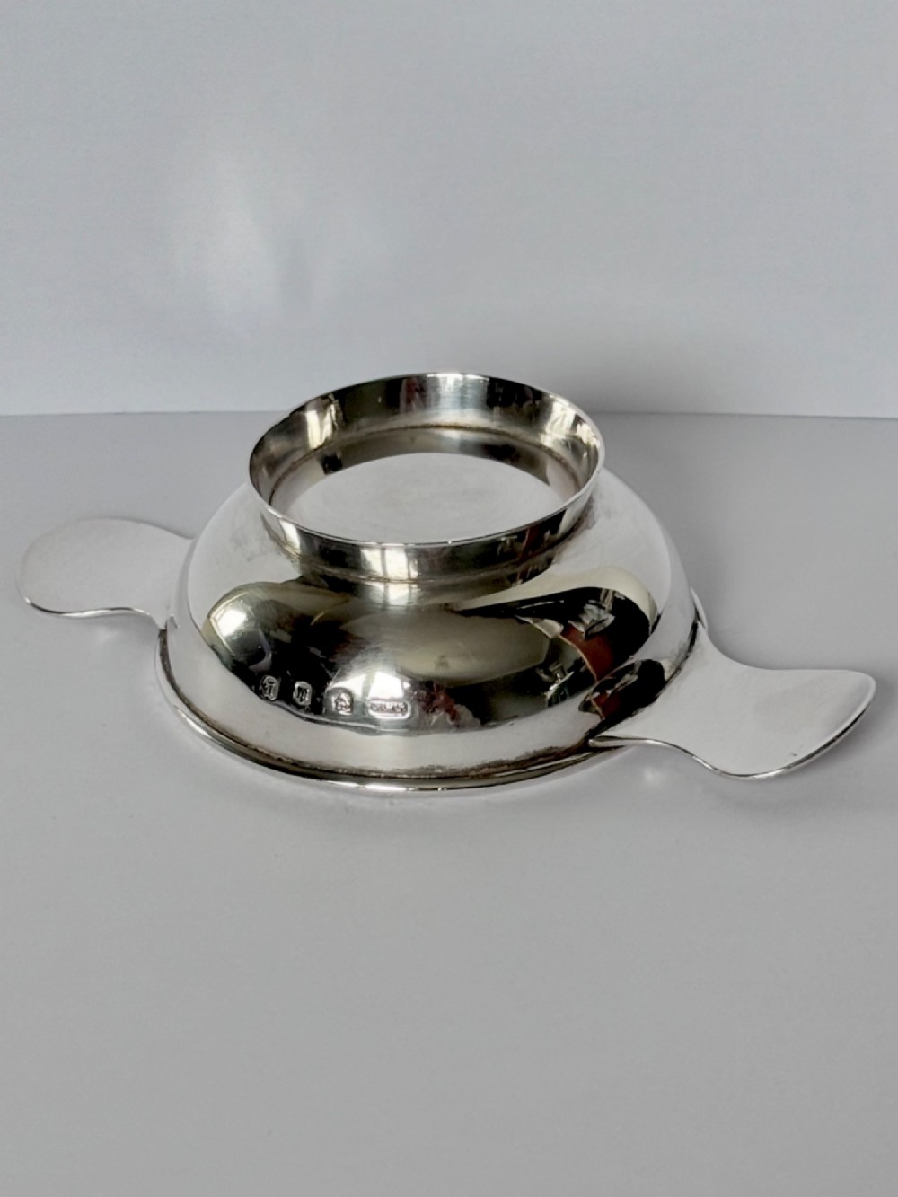 A shallow sterling silver Scottish quaich featuring two flat lug handles and engraved Gaelic lettering in the centre bowl. View VIII