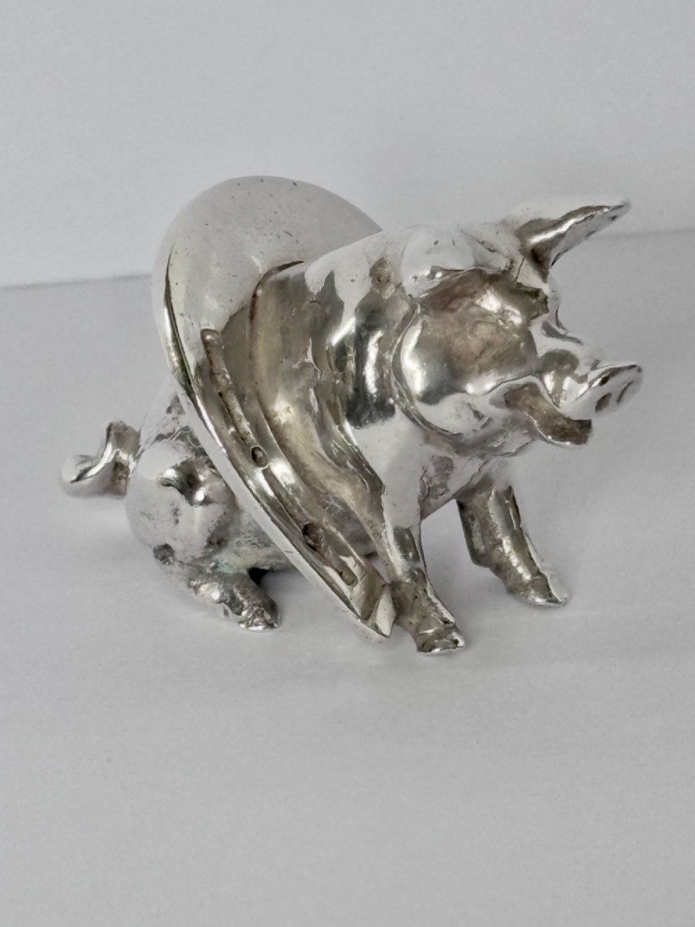 A Victorian sterling silver novelty figurine depicting a pig framed inside a horseshoe. View II