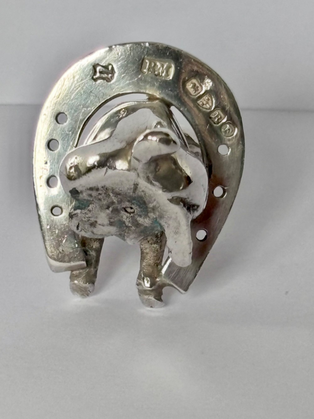 A Victorian sterling silver novelty figurine depicting a pig framed inside a horseshoe. View V
