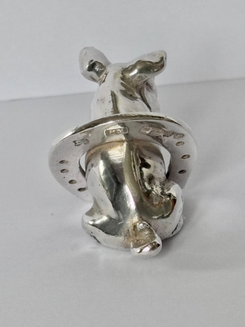 A Victorian sterling silver novelty figurine depicting a pig framed inside a horseshoe. View VI