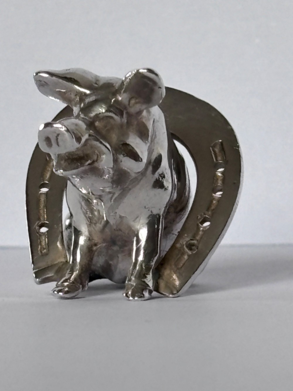 A Victorian sterling silver novelty figurine depicting a pig framed inside a horseshoe. View IX