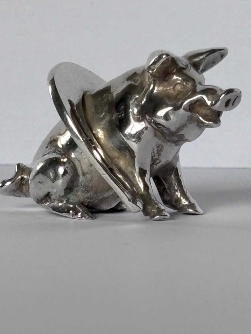 A Victorian sterling silver novelty figurine depicting a pig framed inside a horseshoe. View X