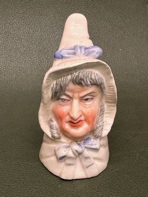 fig 1. An 1893 Royal Worcester porcelain candle extinguisher sculpted in the likeness of Mrs Caudle wearing a white bonnet with a blue ribbon.