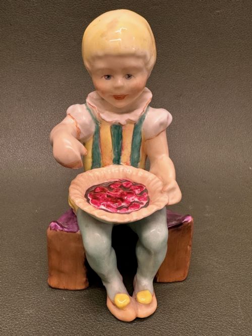 fig 1. A hand-painted Royal Worcester porcelain figurine depicting a seated boy holding a pie, titled Little Jack Horner.