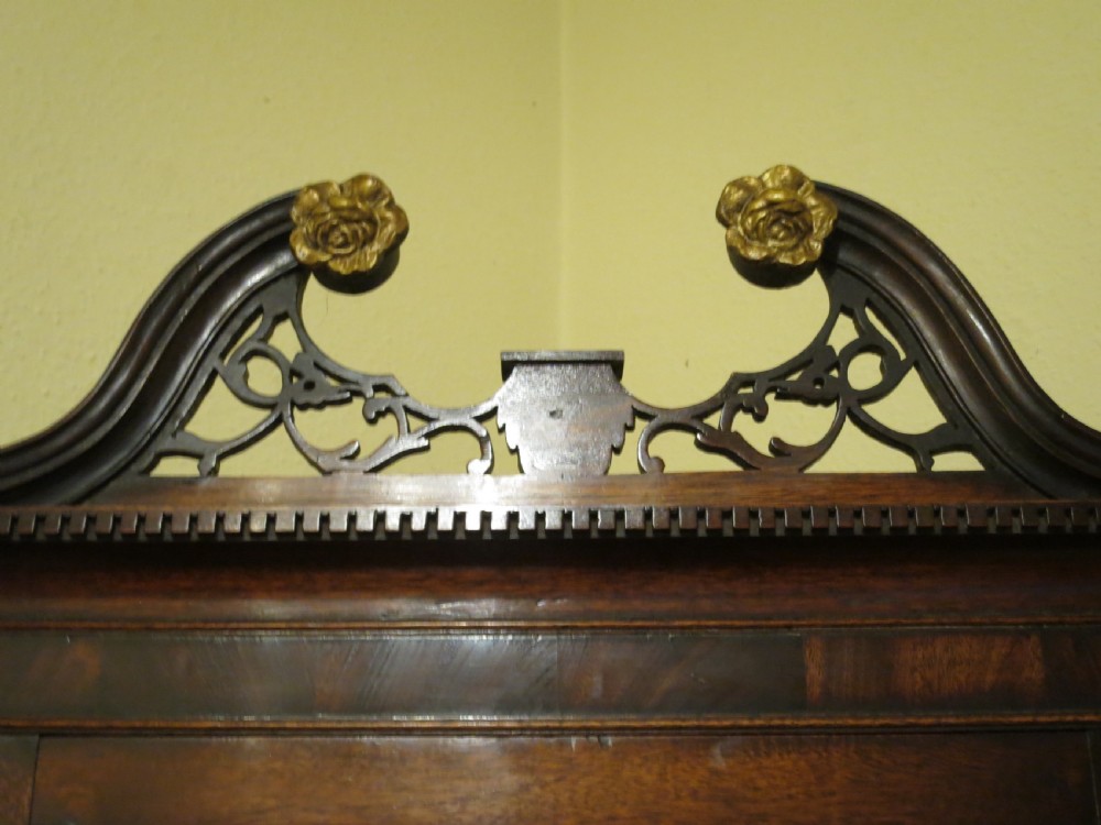 An 18th-century Chippendale mahogany wall-mounted corner cupboard featuring a swan-neck pediment with pierced fretwork and a single panelled door. View III
