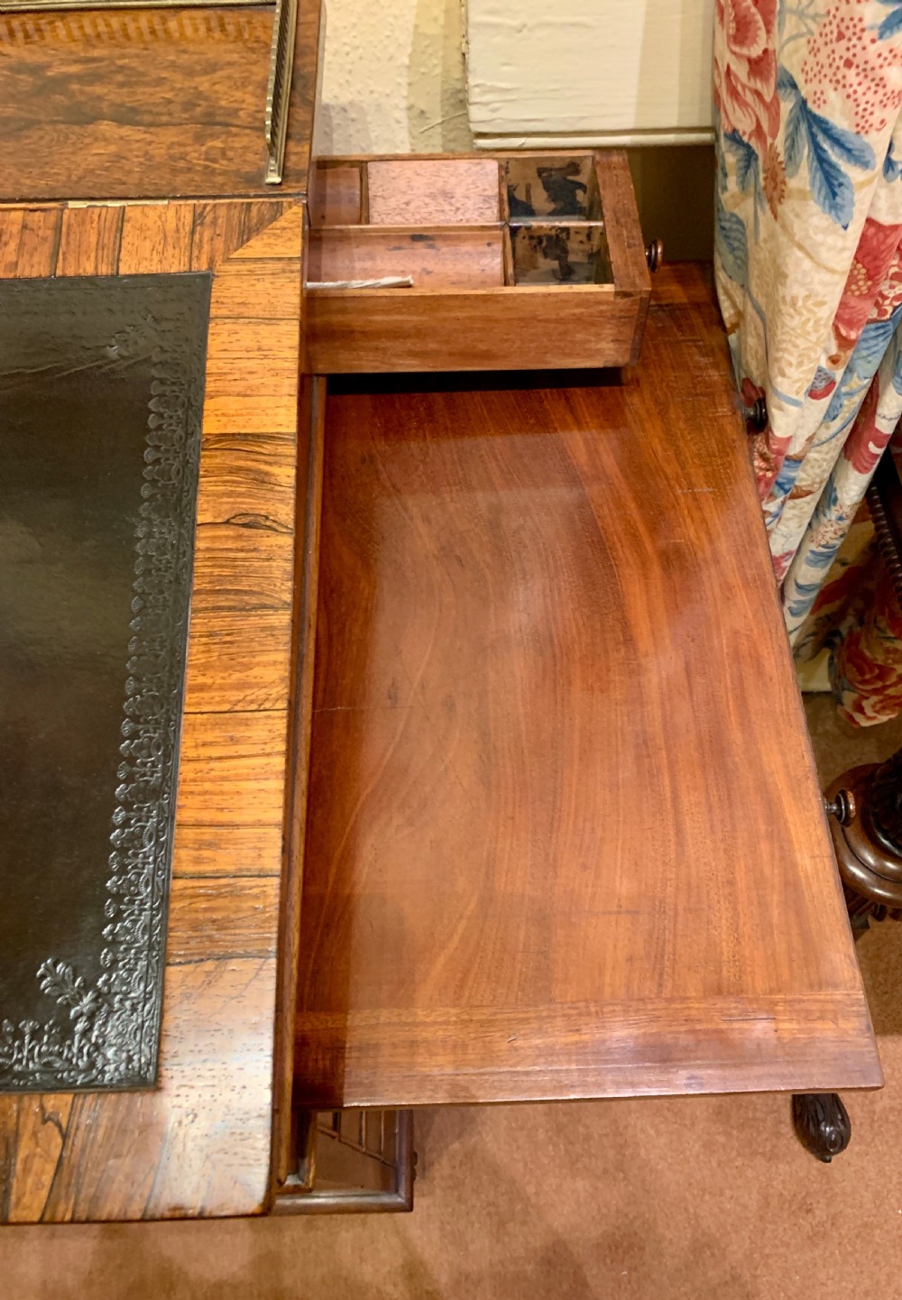 An antique rosewood Davenport desk featuring a sloped leather writing surface, top brass gallery, and side drawers with turned wooden knobs. View IV