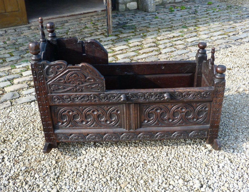 FINE CARVED OAK CRADLE DATED 1677