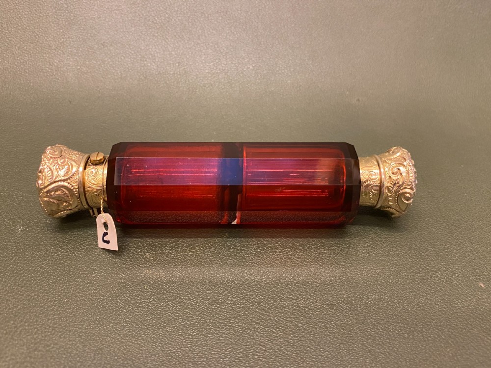 A Ruby glass DOUBLE-ENDED Scent Bottle with embossed gilt metal tops