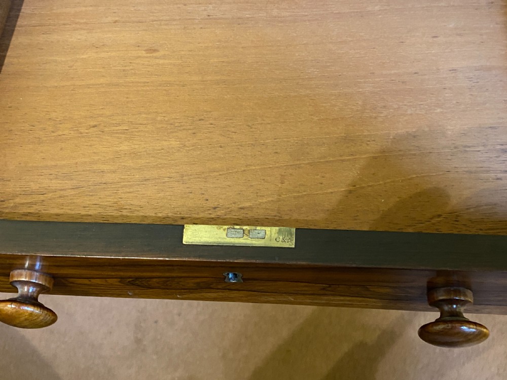 A William IV rosewood writing and work table featuring an adjustable leather-inset writing slope, drop-leaf sides, two drawers, and reeded turned legs on brass castors. View XI