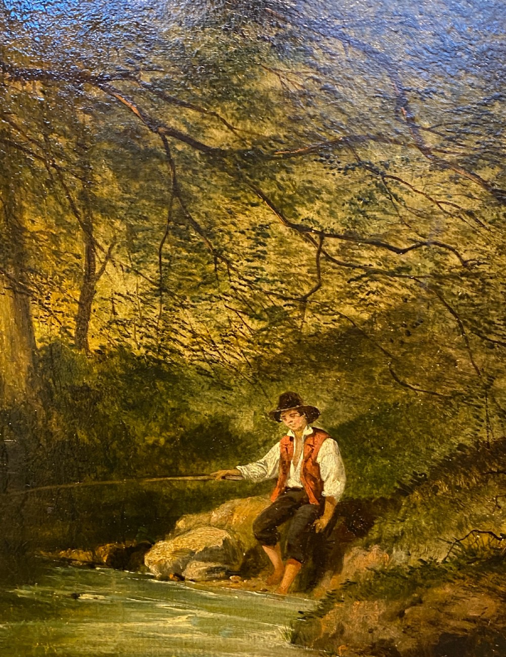 An 1856 Victorian oil painting on board depicting a figure fishing along a wooded stream, displayed inside a gilded frame. View VII