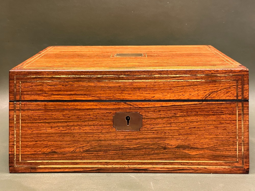 An open 19th-century kingwood dressing case with brass inlay, lined in blue velvet and fitted with silver-topped glass bottles, silver containers, and manicure tools. View XXII
