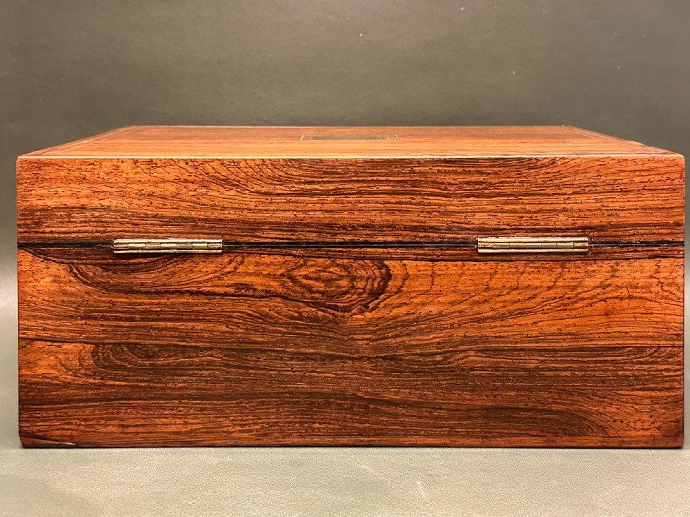 An open 19th-century kingwood dressing case with brass inlay, lined in blue velvet and fitted with silver-topped glass bottles, silver containers, and manicure tools. View XXIV