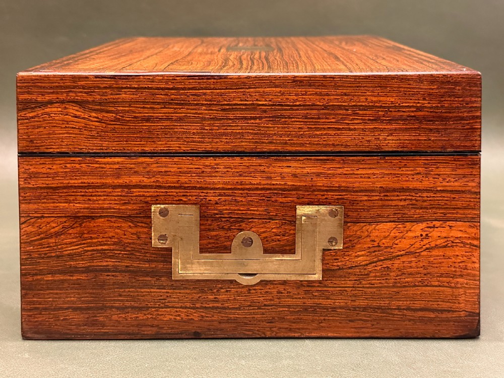 An open 19th-century kingwood dressing case with brass inlay, lined in blue velvet and fitted with silver-topped glass bottles, silver containers, and manicure tools. View XXV