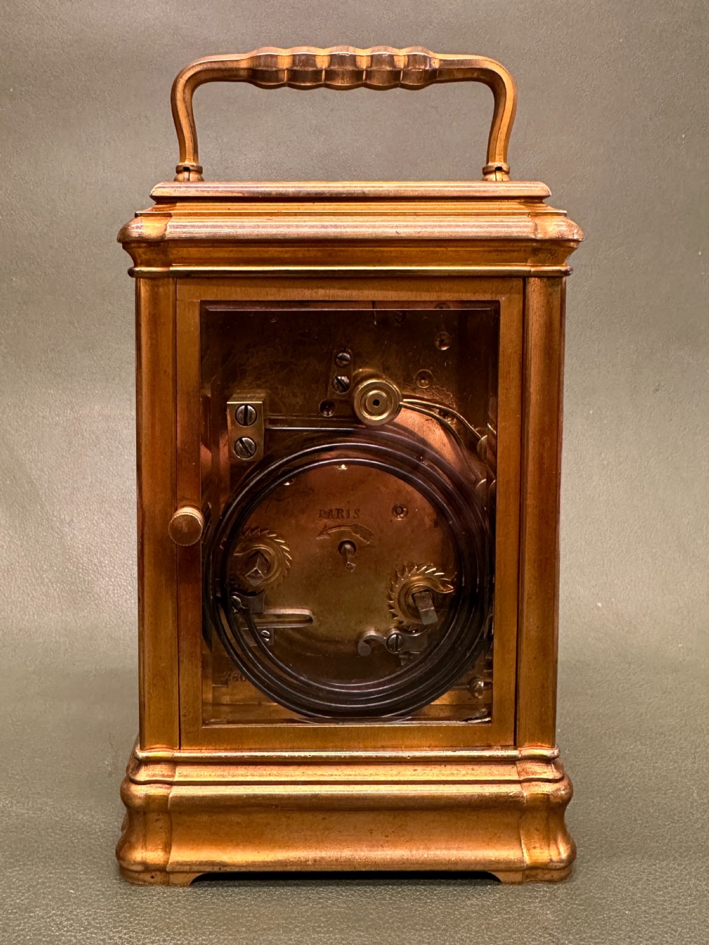 A Victorian gilt brass carriage clock with a white enamel dial next to its leather travelling box and double-ended winding key. View V