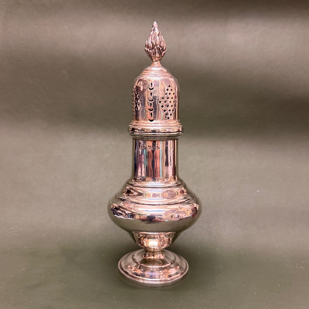 A polished silver pear-shaped sugar sifter featuring a pierced domed lid and a flared footed base.