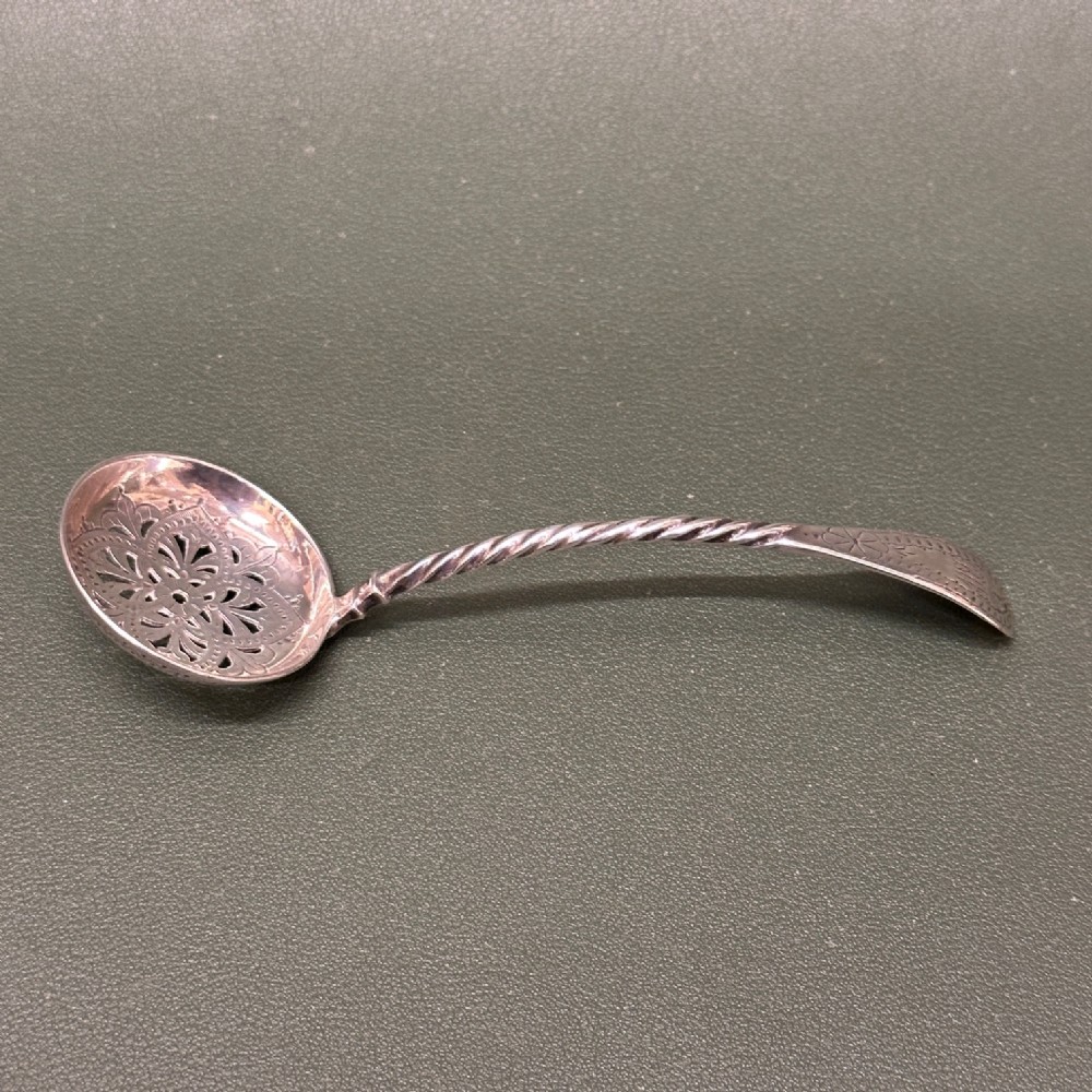 A Victorian hallmarked sterling silver mote spoon featuring a decorative pierced oval bowl and a twisted stem.