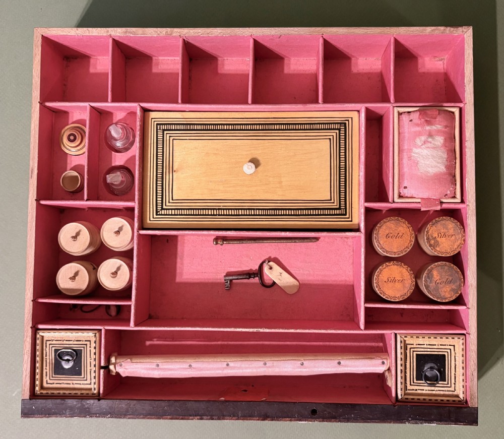 A square Regency burr walnut workbox with a central classical medallion print, decorative printed border, brass side handles, and a lower drawer. View III