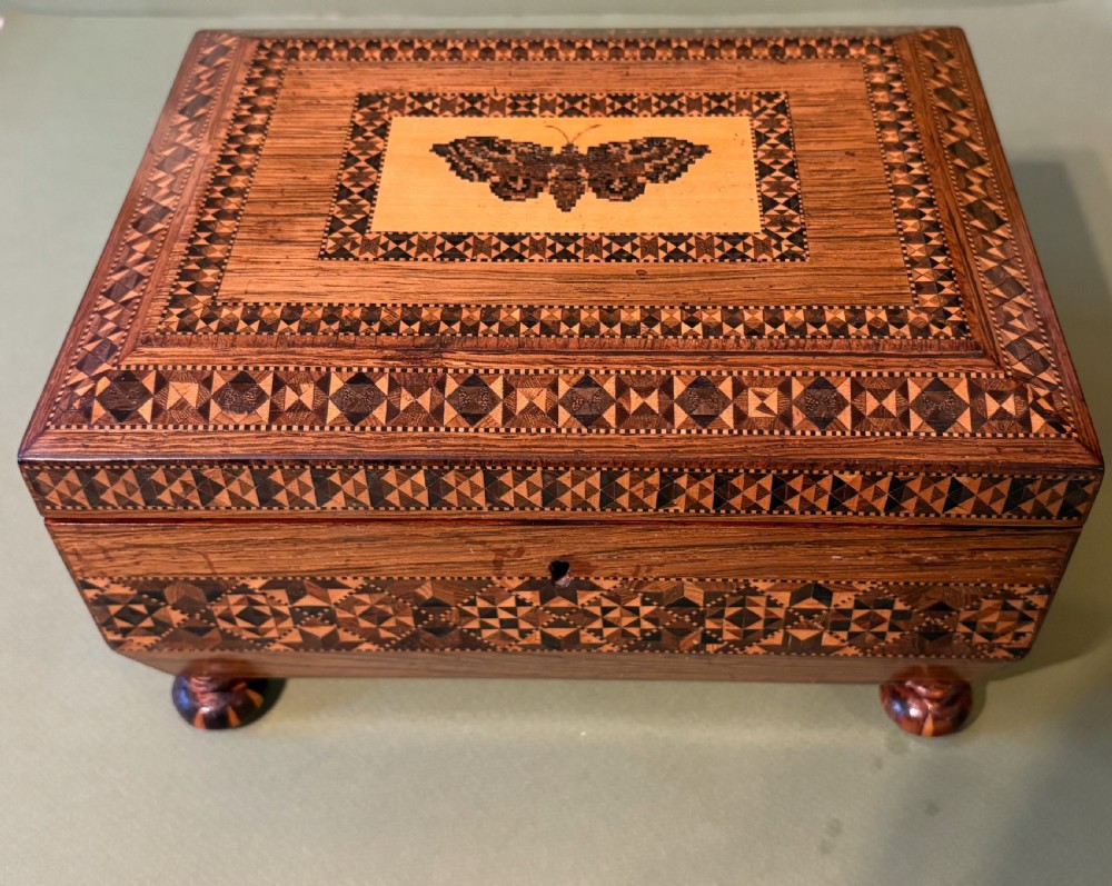 An open Victorian rosewood sewing box featuring geometric Tunbridge ware mosaic inlay, a pink silk interior, and fitted compartments containing sewing tools. View VII