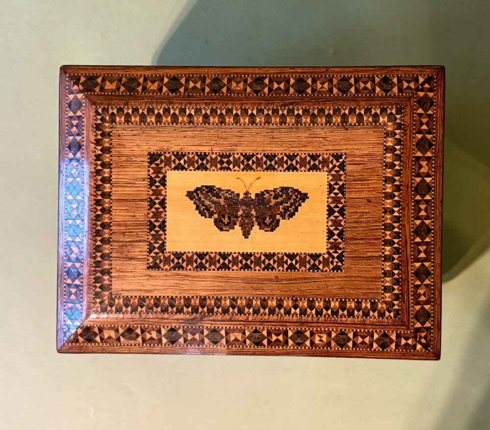 An open Victorian rosewood sewing box featuring geometric Tunbridge ware mosaic inlay, a pink silk interior, and fitted compartments containing sewing tools. View VIII