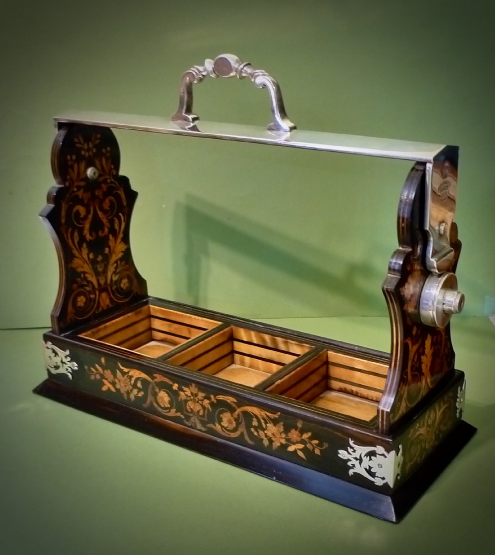 A Victorian three-bottle cut crystal decanter tantalus housed in a dark wooden frame with floral marquetry inlay and a silver-toned metal locking top handle. View IV