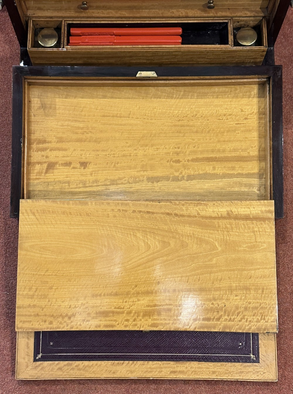 A rectangular dark rosewood writing box featuring central satinwood marquetry of an urn with foliate scrolls and a central brass keyhole escutcheon. View V