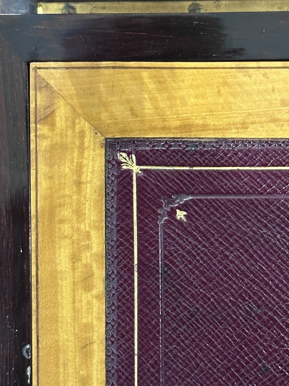 A rectangular dark rosewood writing box featuring central satinwood marquetry of an urn with foliate scrolls and a central brass keyhole escutcheon. View VI