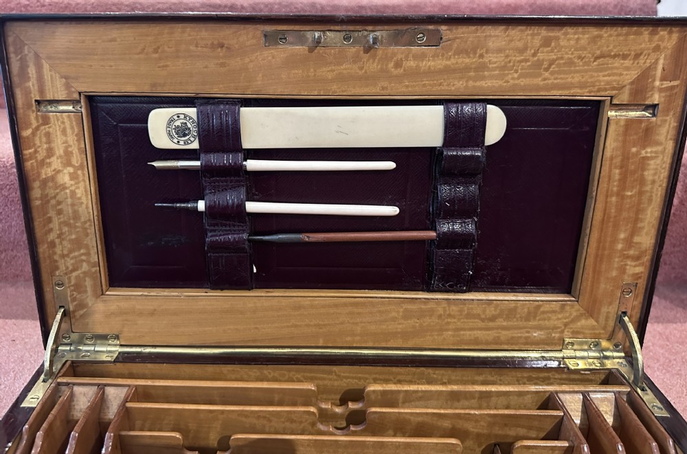 A rectangular dark rosewood writing box featuring central satinwood marquetry of an urn with foliate scrolls and a central brass keyhole escutcheon. View IX