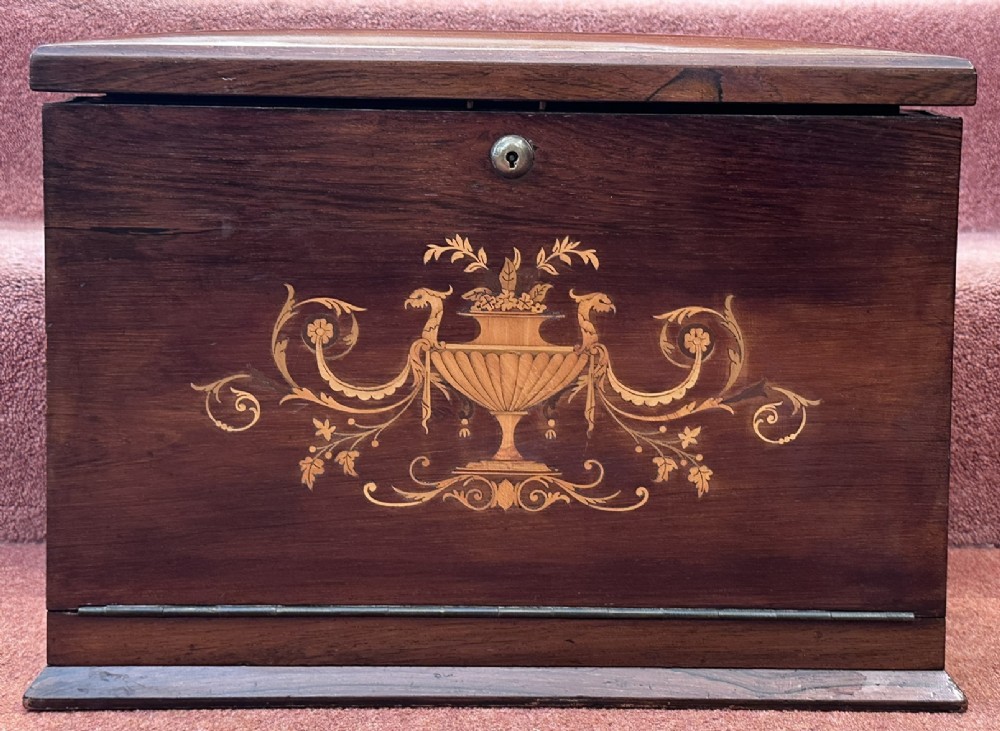 A rectangular dark rosewood writing box featuring central satinwood marquetry of an urn with foliate scrolls and a central brass keyhole escutcheon. View XII