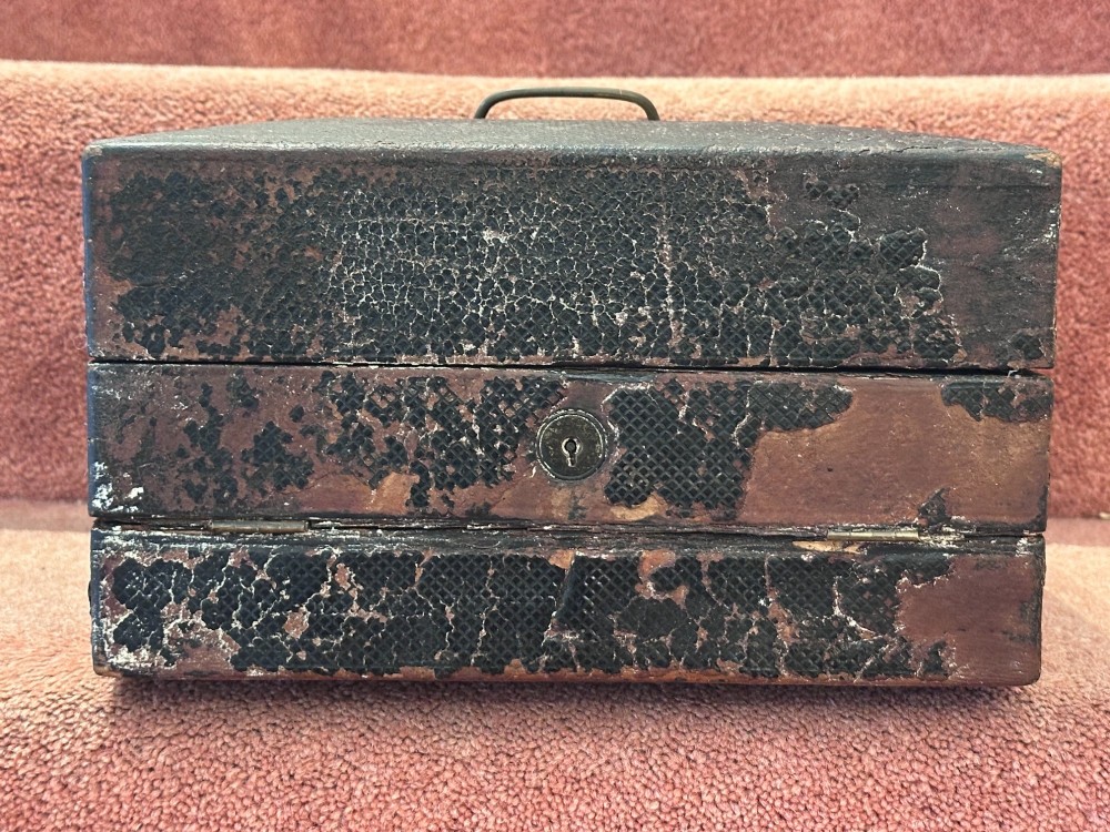 An open Victorian leather-bound writing box featuring internal letter slots, a pen tray, an inkwell compartment, and brass hardware. View X