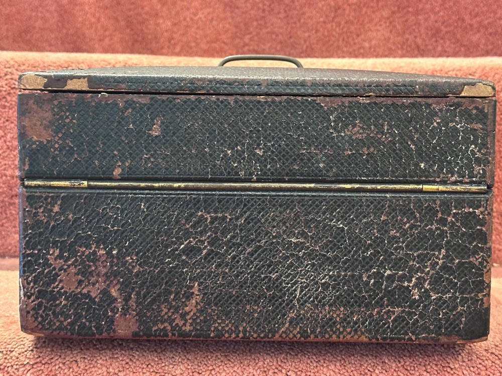An open Victorian leather-bound writing box featuring internal letter slots, a pen tray, an inkwell compartment, and brass hardware. View XII