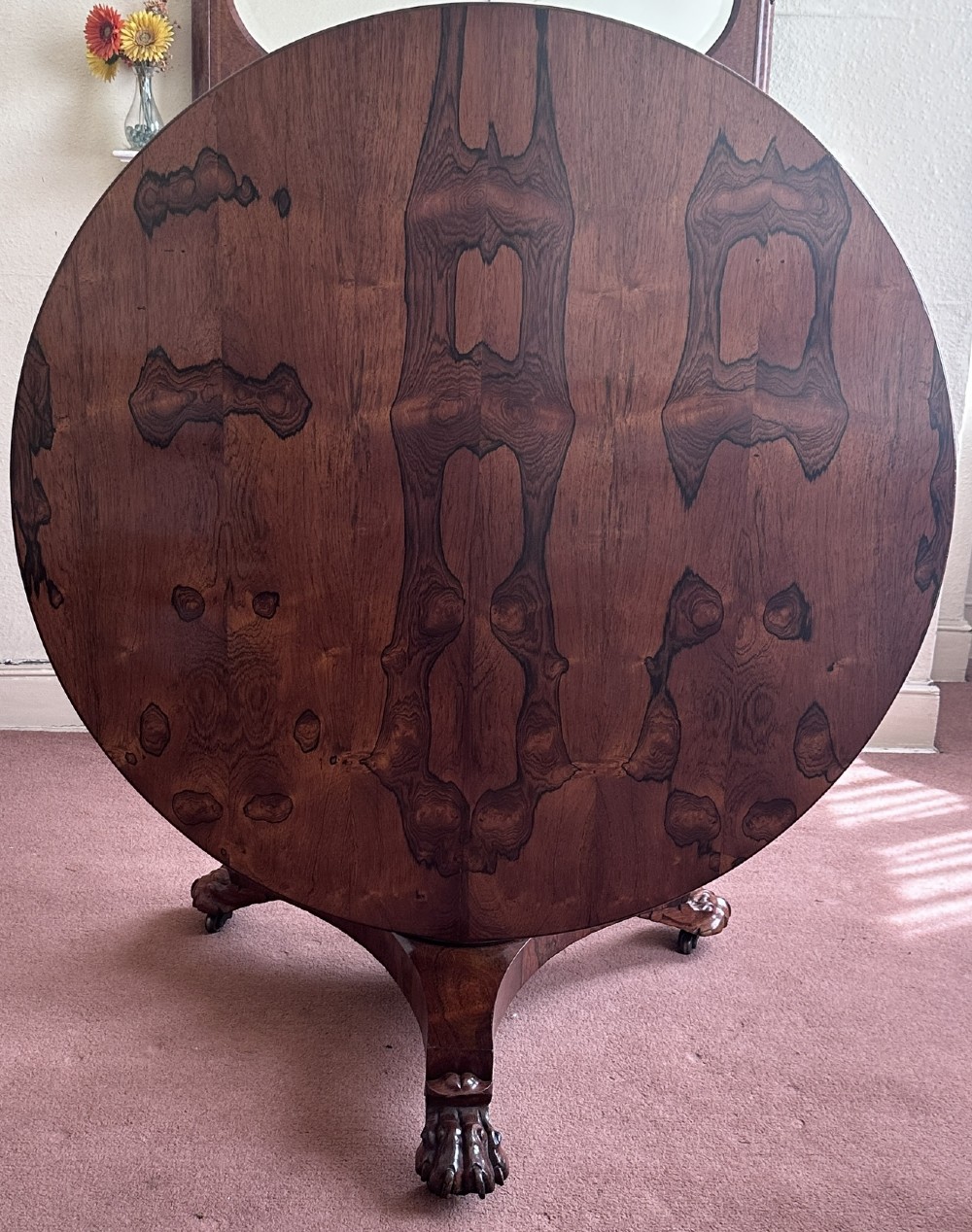 A circular William IV tilt-top rosewood centre table featuring symmetrical book-matched veneer and a central pedestal base with carved claw feet. View II
