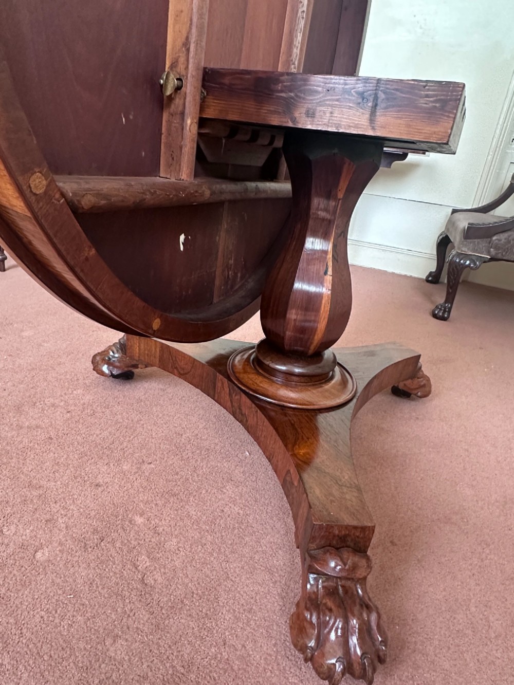 A circular William IV tilt-top rosewood centre table featuring symmetrical book-matched veneer and a central pedestal base with carved claw feet. View V