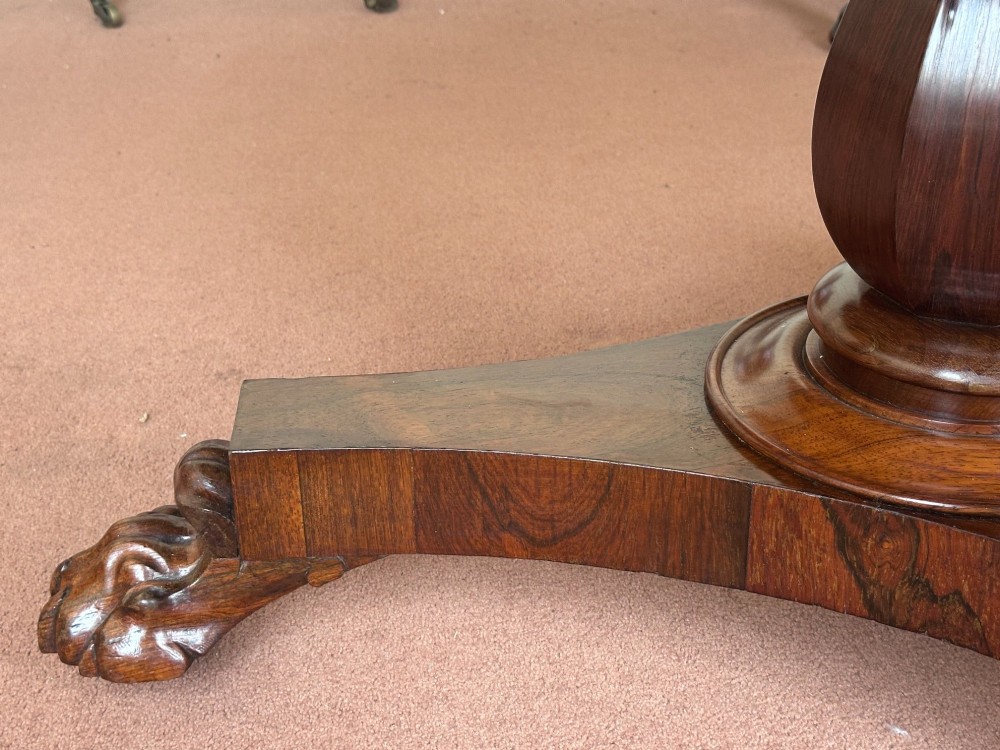 A circular William IV tilt-top rosewood centre table featuring symmetrical book-matched veneer and a central pedestal base with carved claw feet. View IX