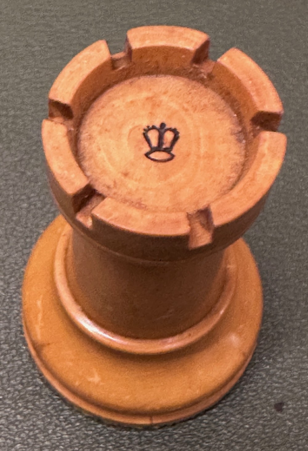 A complete set of carved boxwood and ebonised black Staunton pattern chess pieces displayed in front of a warm mahogany wooden box with a sliding lid. View III