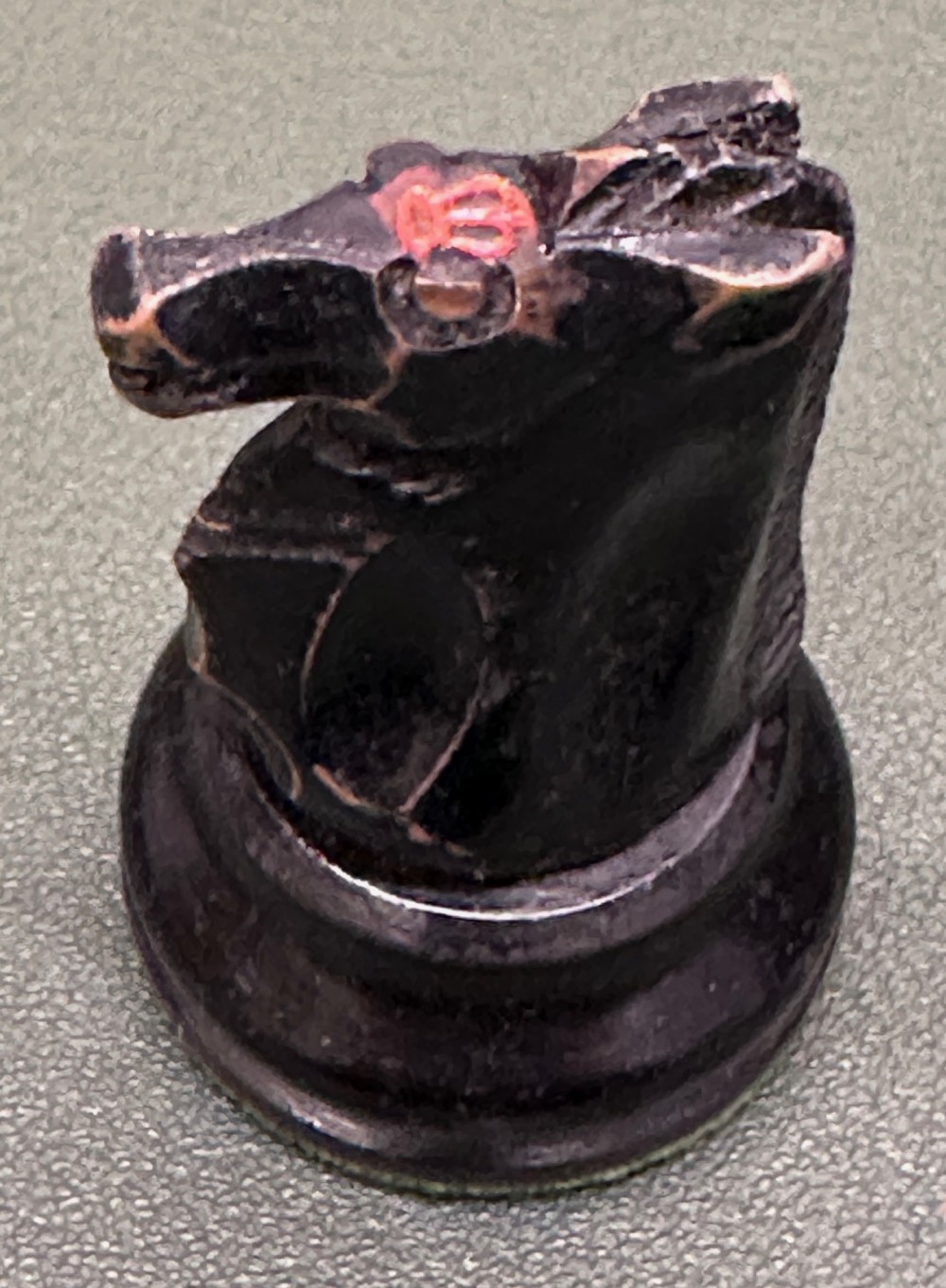 A complete set of carved boxwood and ebonised black Staunton pattern chess pieces displayed in front of a warm mahogany wooden box with a sliding lid. View VI