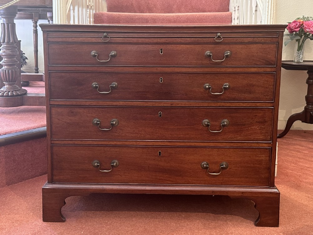 An 18th-century George III mahogany bachelors chest featuring four graduated drawers, brass swan-neck handles, a pull-out brushing slide, and bracket feet. View II