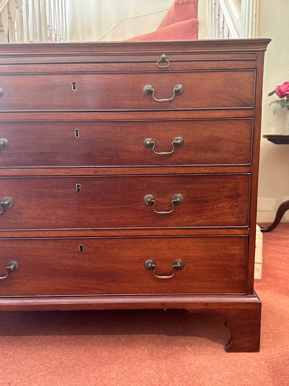 An 18th-century George III mahogany bachelors chest featuring four graduated drawers, brass swan-neck handles, a pull-out brushing slide, and bracket feet. View III