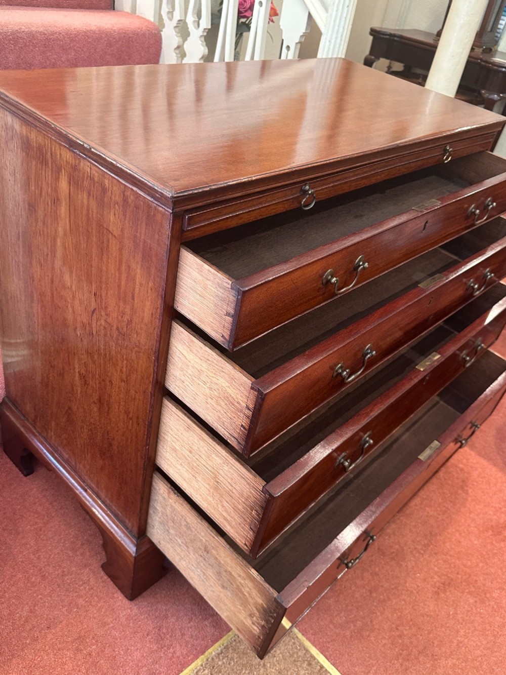 An 18th-century George III mahogany bachelors chest featuring four graduated drawers, brass swan-neck handles, a pull-out brushing slide, and bracket feet. View VIII