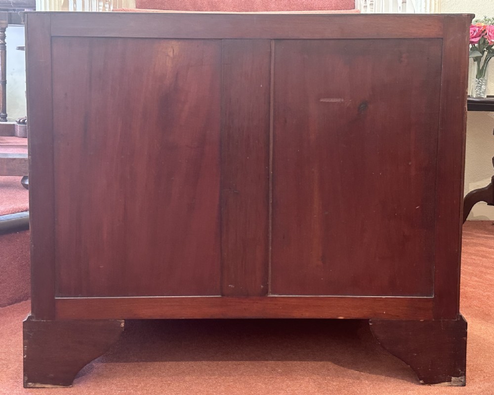 An 18th-century George III mahogany bachelors chest featuring four graduated drawers, brass swan-neck handles, a pull-out brushing slide, and bracket feet. View X
