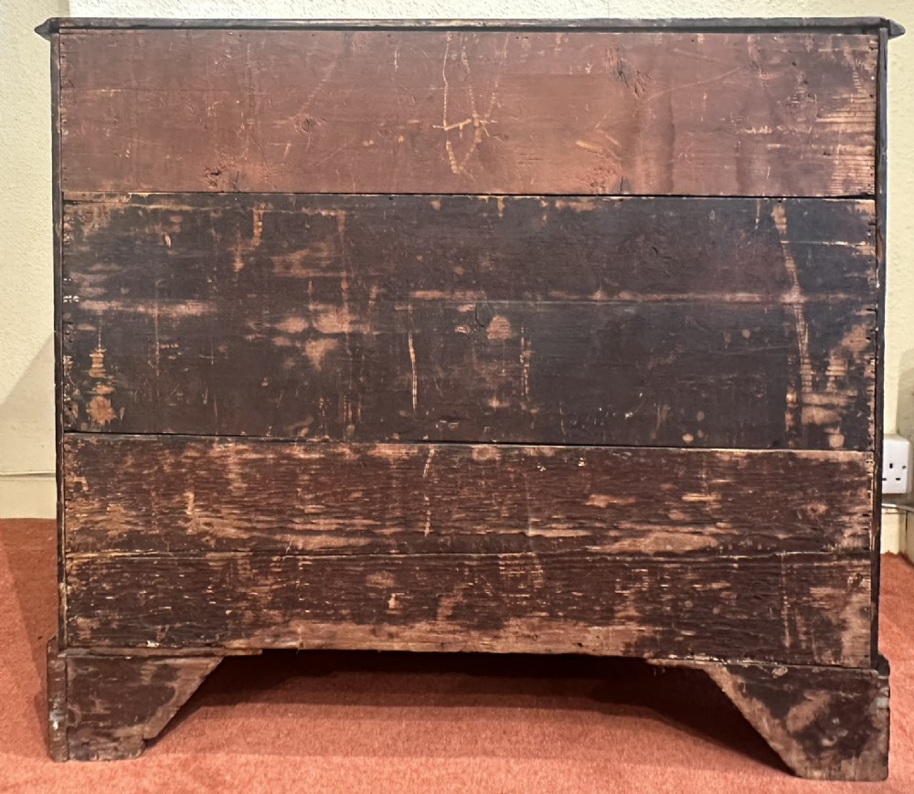 A George III dark mahogany bachelors chest featuring four graduated drawers, brass swan-neck handles, keyhole escutcheons, a pull-out brushing slide, and bracket feet. View VII