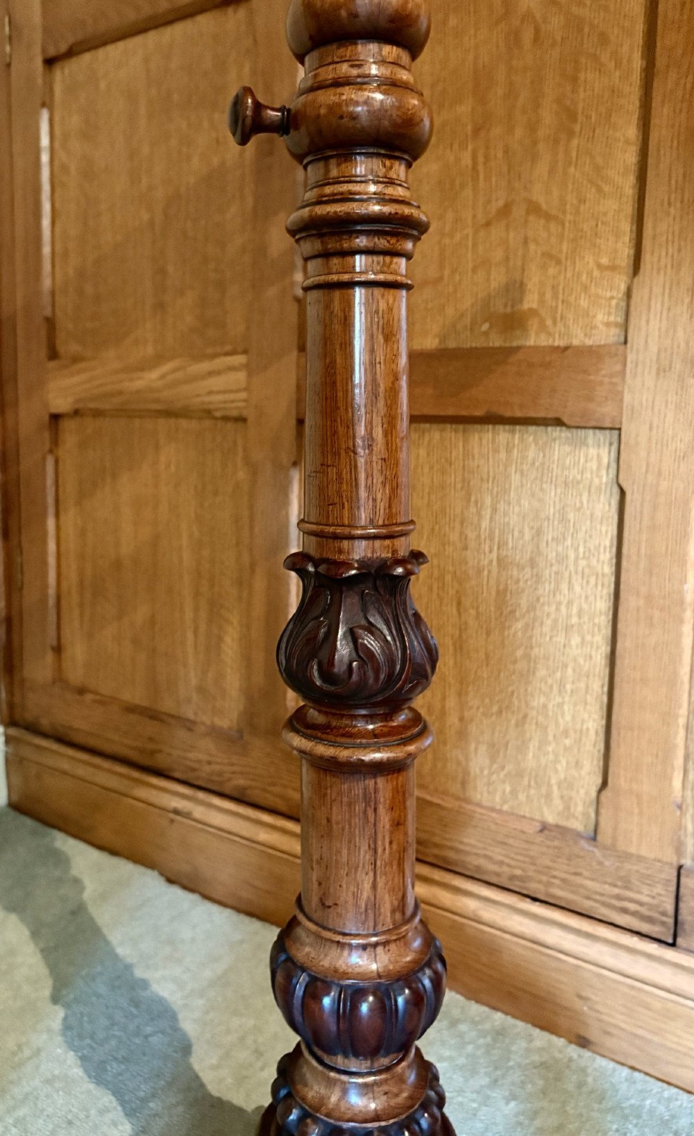 An antique mahogany duet music stand with a double slatted desk, brass candle sconces, a turned central column, and carved tripod scroll legs. View III