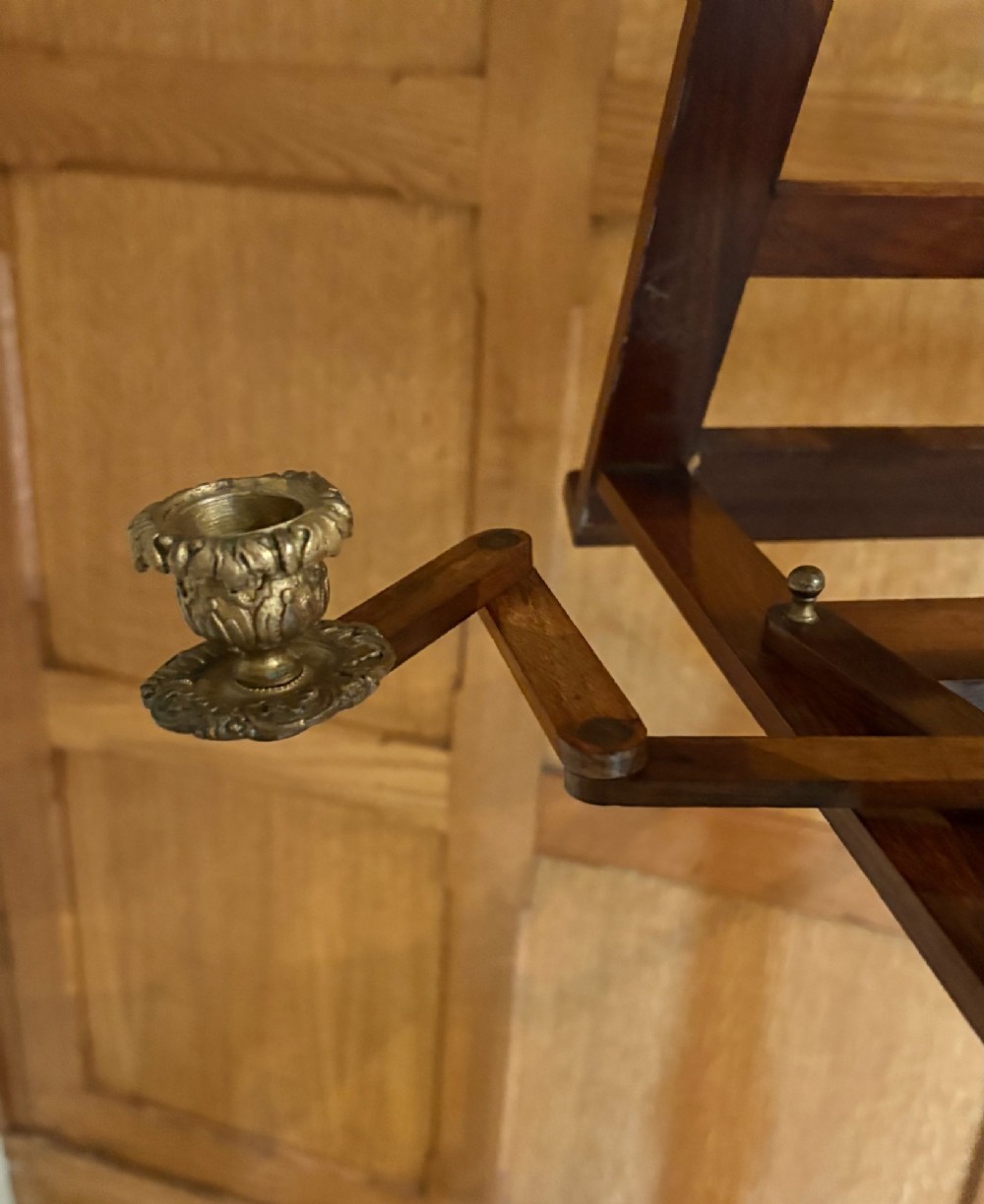 An antique mahogany duet music stand with a double slatted desk, brass candle sconces, a turned central column, and carved tripod scroll legs. View V
