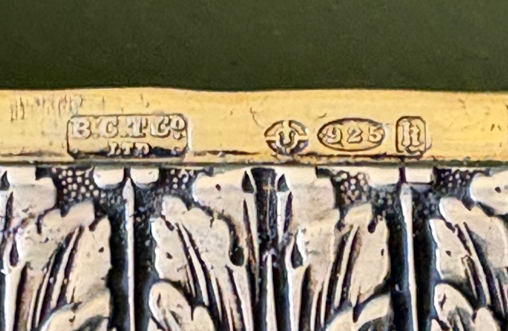 A rectangular silver snuff box decorated with floral relief work and a central oval portrait miniature of a woman. View V