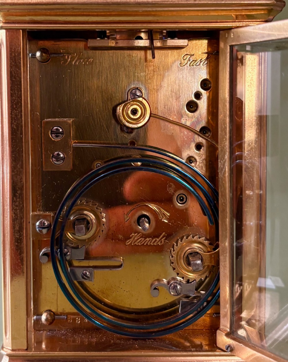 A 19th-century French gilt brass carriage clock with bevelled glass side panels, an enamel dial with Roman numerals, and a hinged top carrying handle. View IV