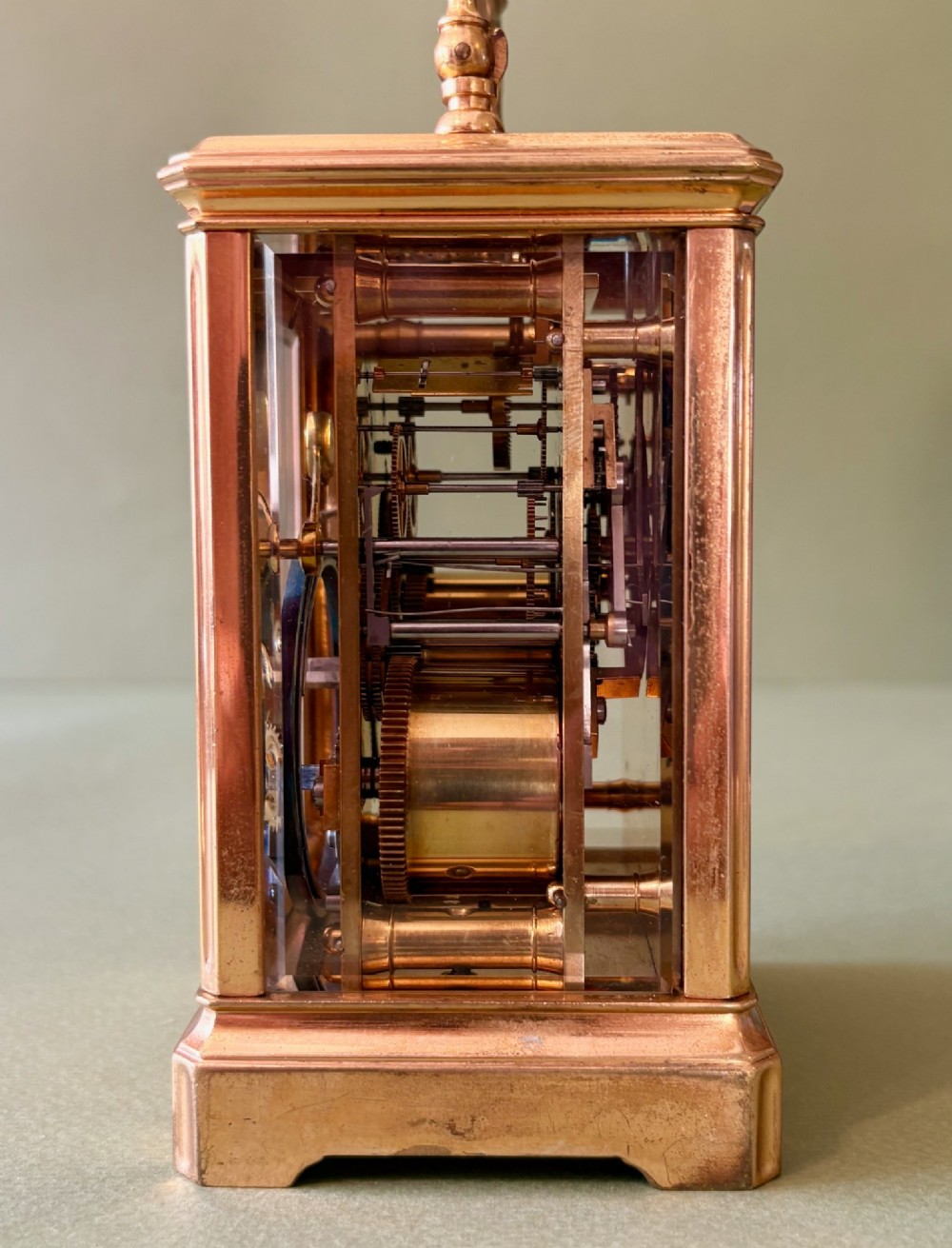 A 19th-century French gilt brass carriage clock with bevelled glass side panels, an enamel dial with Roman numerals, and a hinged top carrying handle. View V