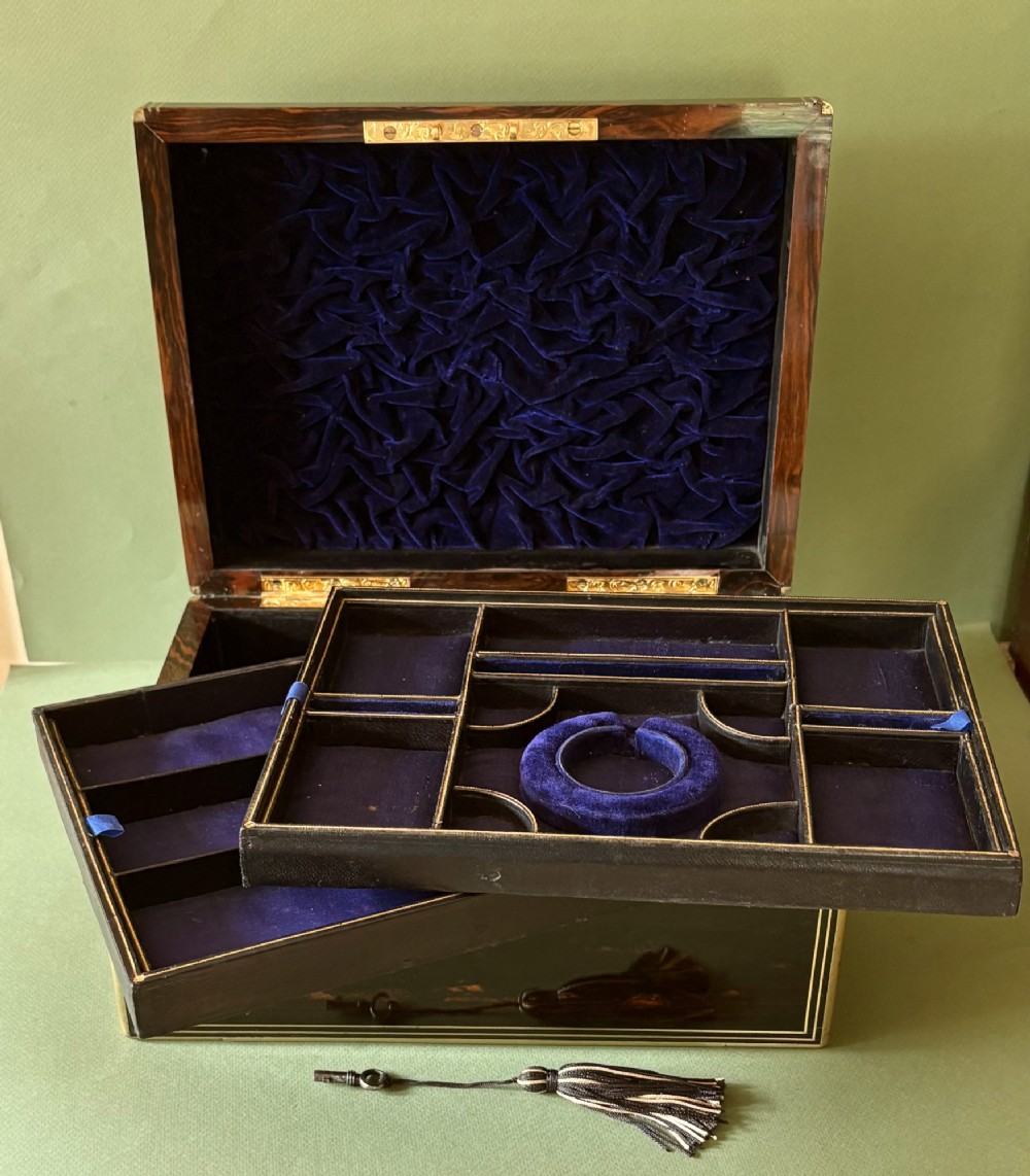 An open Victorian rosewood jewellery box featuring brass inlay stringing, a central keyhole escutcheon, and a deep blue velvet fitted interior with compartments. View II